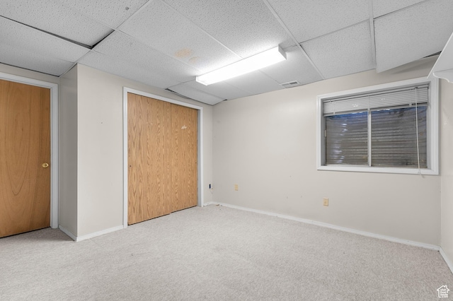 spare room with a drop ceiling, carpet, baseboards, and visible vents