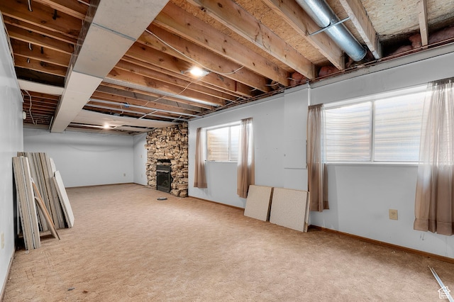 below grade area with baseboards, carpet flooring, and a fireplace
