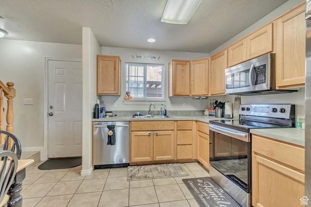 333 S Monroe Blvd Unit 23, Ogden, UT 84404 - kitchen with light countertops, light tile patterned floors, a sink, light brown cabinets, and appliances with stainless steel finishes