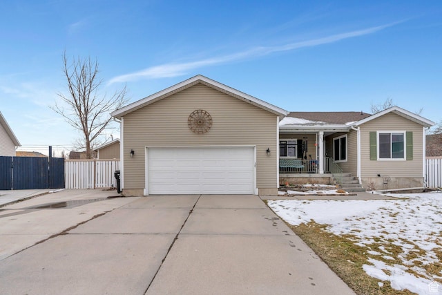 single story home with a porch, driveway, a garage, and fence