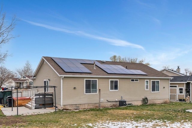 rear view of property with a lawn, central AC, roof with shingles, and a wooden deck