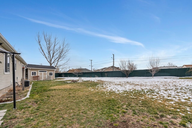 view of yard with central AC unit and fence
