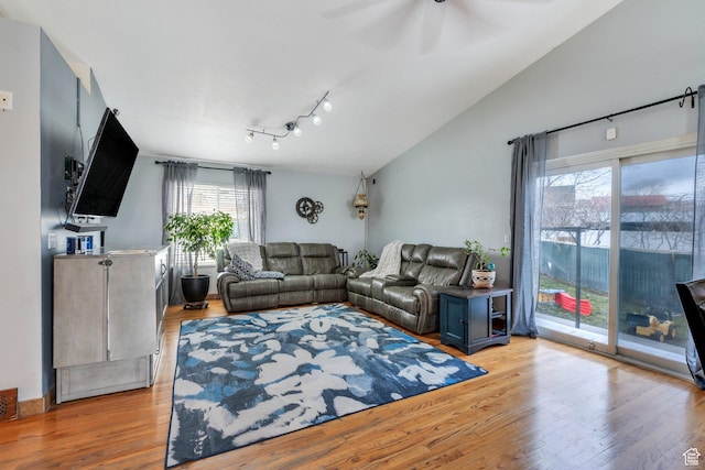 living area featuring light wood-style flooring, lofted ceiling, and ceiling fan