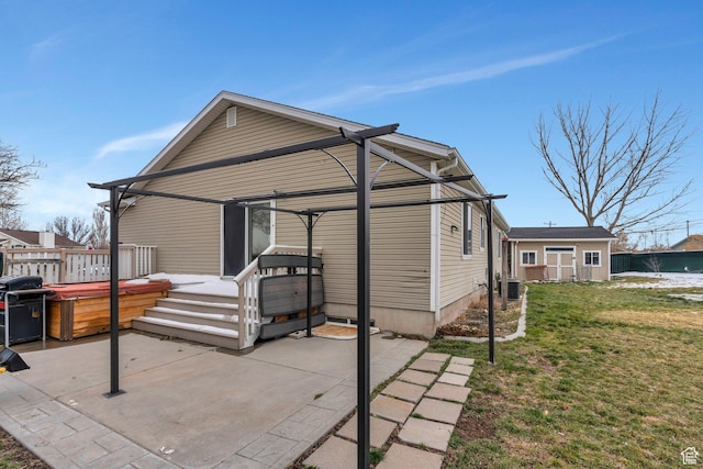 exterior space with a lawn, a hot tub, a wooden deck, and central air condition unit