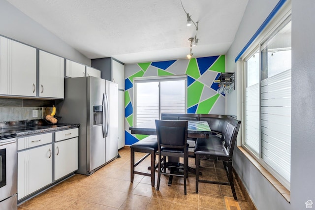 kitchen featuring decorative backsplash, a textured ceiling, visible vents, appliances with stainless steel finishes, and white cabinetry