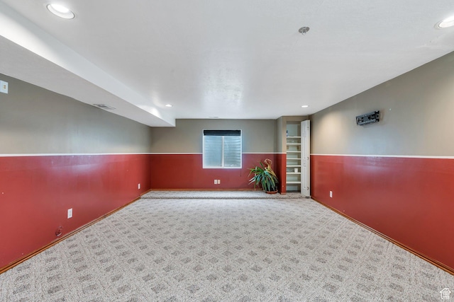 carpeted spare room featuring a wainscoted wall, visible vents, and recessed lighting
