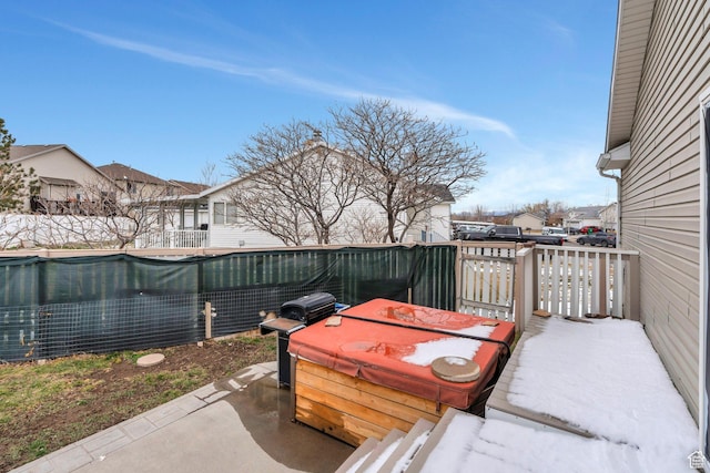 view of patio / terrace with a jacuzzi, a residential view, a grill, and fence