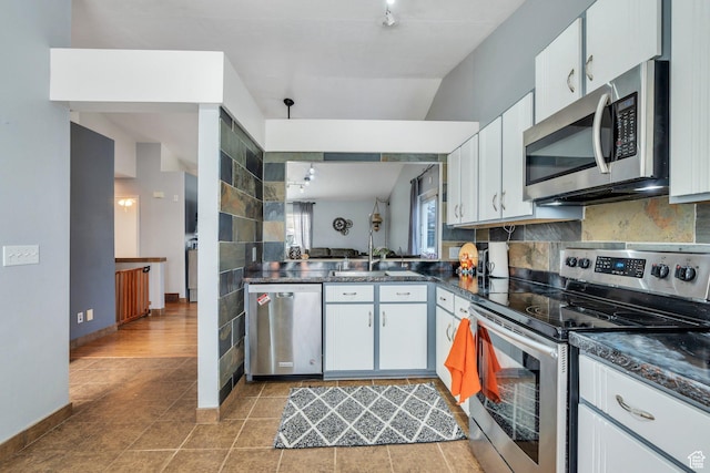 kitchen featuring a sink, dark countertops, tasteful backsplash, and appliances with stainless steel finishes