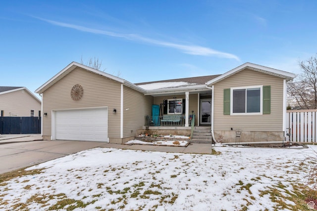 ranch-style home with fence, driveway, covered porch, and a garage