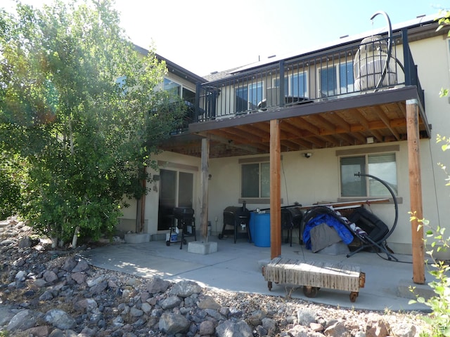 4613 W Brookport Cir S Unit V3-8, Herriman, UT 84096 - rear view of house featuring stucco siding, a patio, and a balcony