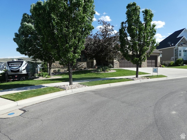 4613 W Brookport Cir S Unit V3-8, Herriman, UT 84096 - view of front of house with stone siding, driveway, a front lawn, and an attached garage