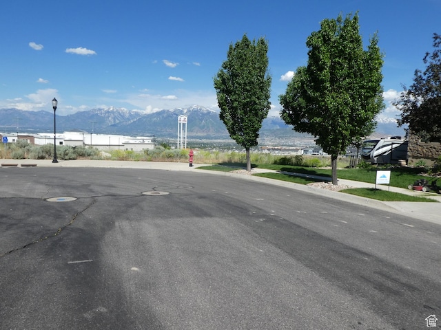 4613 W Brookport Cir S Unit V3-8, Herriman, UT 84096 - view of asphalt street with a mountain view, street lights, and sidewalks