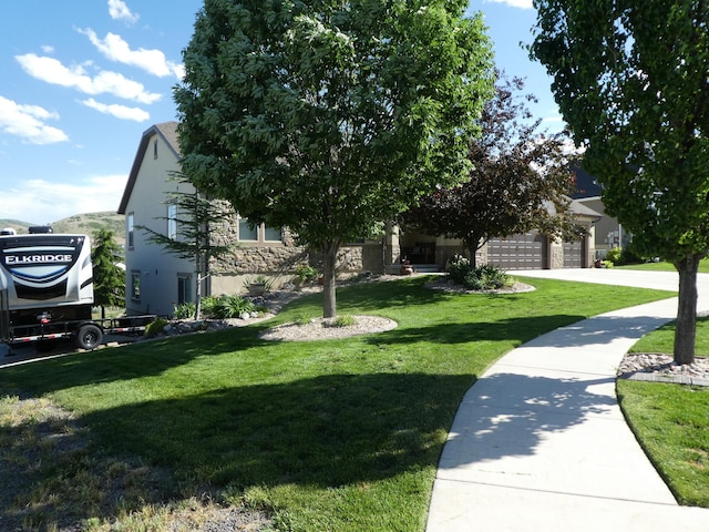 4613 W Brookport Cir S Unit V3-8, Herriman, UT 84096 - view of front of property with a front yard, stone siding, a garage, and stucco siding