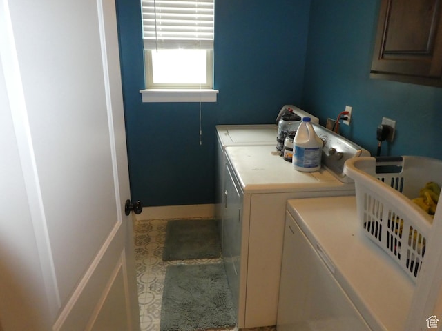 clothes washing area with cabinet space, baseboards, and separate washer and dryer
