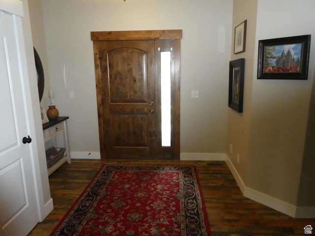 foyer entrance featuring baseboards and dark wood finished floors