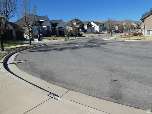view of street with sidewalks, a residential view, and curbs