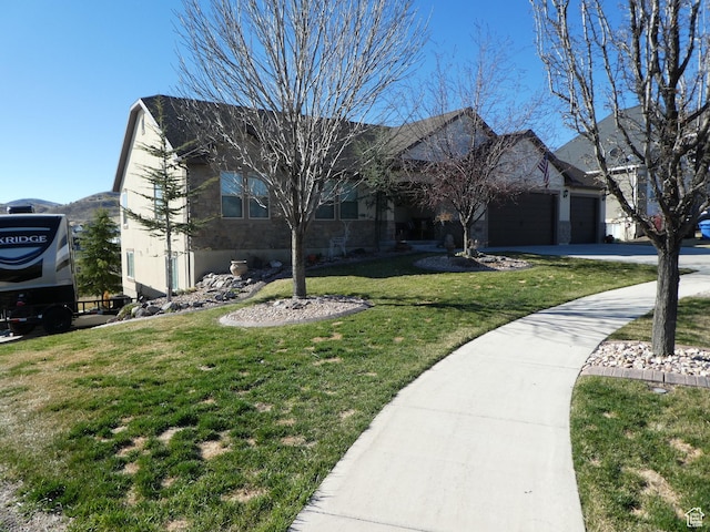 view of front of house featuring a front lawn, an attached garage, and concrete driveway