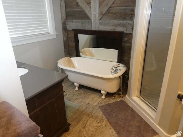bathroom featuring a freestanding tub, wood finished floors, a stall shower, and vanity