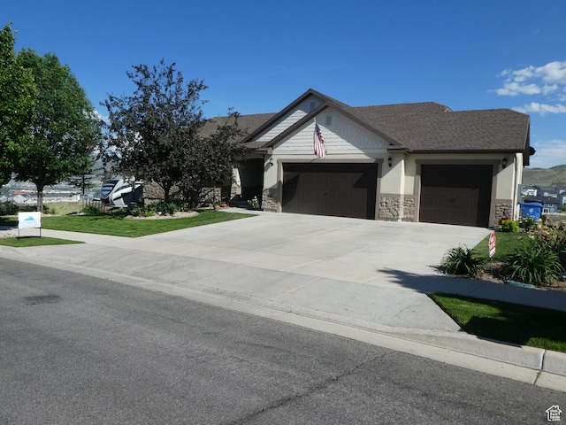 4613 W Brookport Cir S Unit V3-8, Herriman, UT 84096 - view of front of house featuring a garage, concrete driveway, stone siding, and a front yard