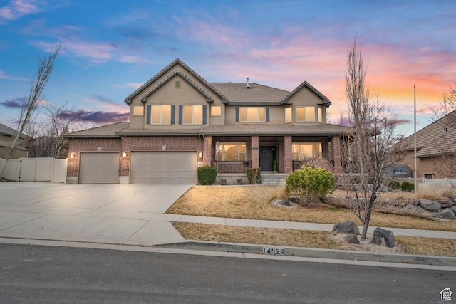 view of front of home featuring fence, an attached garage, brick siding, driveway, and a porch