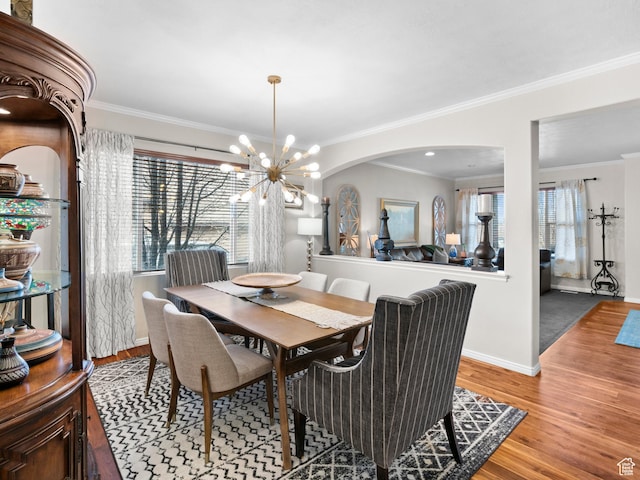 14526 Long Ridge Dr, Herriman, UT 84096 - dining area with a chandelier, wood finished floors, baseboards, arched walkways, and ornamental molding