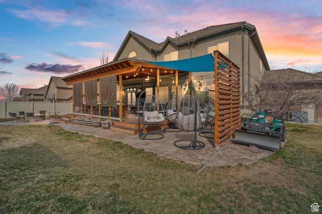 14526 Long Ridge Dr, Herriman, UT 84096 - back of house at dusk featuring a patio area, stucco siding, fence, and a yard