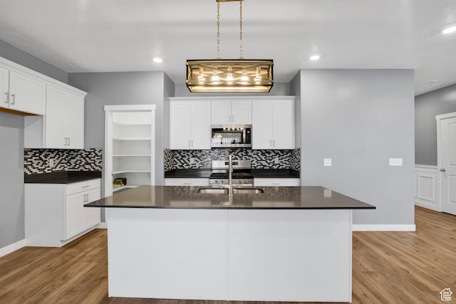 900 E Mecham Ave, Layton, UT 84040 - kitchen featuring light wood finished floors, stainless steel appliances, dark countertops, white cabinetry, and a sink
