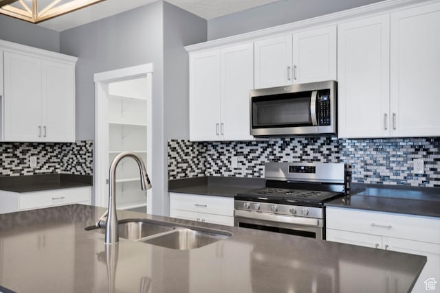 900 E Mecham Ave, Layton, UT 84040 - kitchen featuring white cabinetry, a sink, stainless steel appliances, and dark countertops