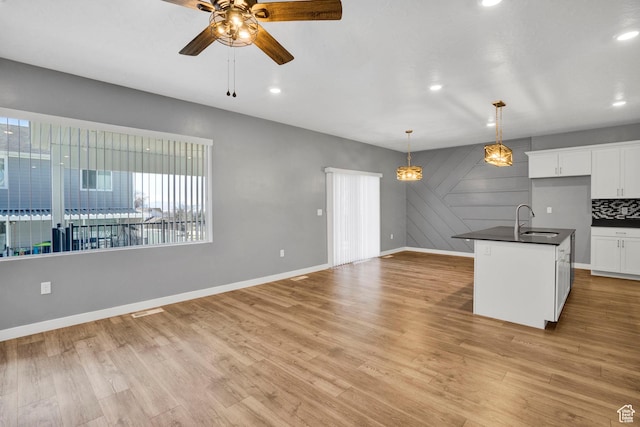 900 E Mecham Ave, Layton, UT 84040 - kitchen with a ceiling fan, light wood-style flooring, a sink, and dark countertops