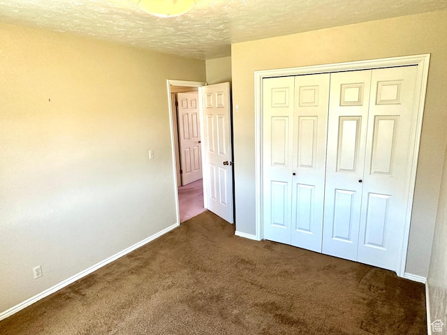 2662 W Toni Lee St, West Jordan, UT 84088 - unfurnished bedroom featuring a closet, a textured ceiling, baseboards, and dark colored carpet