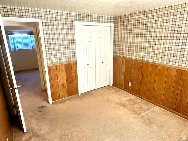 2662 W Toni Lee St, West Jordan, UT 84088 - unfurnished bedroom featuring a closet, a textured ceiling, wallpapered walls, carpet floors, and wainscoting