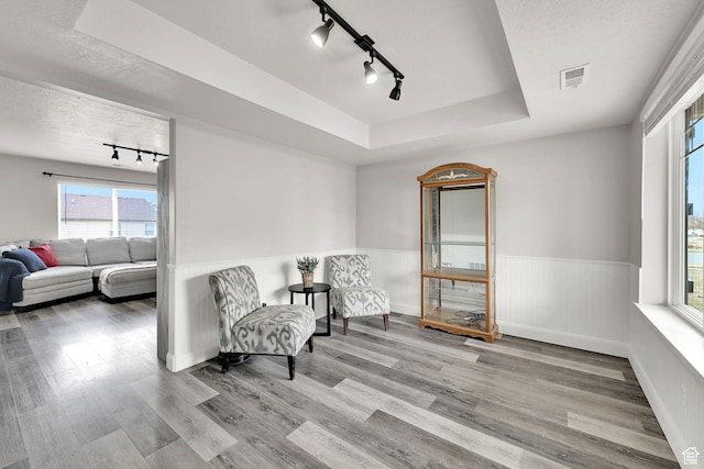 198 S 1130 E, Hyrum, UT 84319 - living area with a raised ceiling, wood finished floors, a textured ceiling, wainscoting, and visible vents