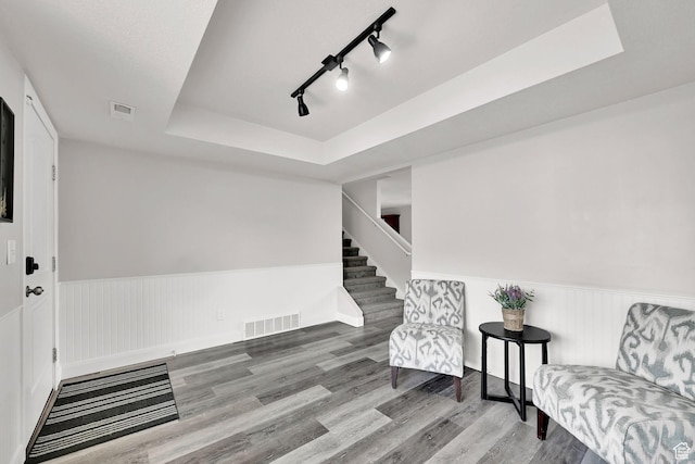 198 S 1130 E, Hyrum, UT 84319 - living area with a tray ceiling, stairs, wood finished floors, wainscoting, and visible vents