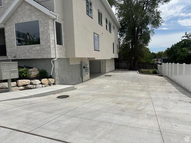 1562 E 3900 S Unit 107, Millcreek, UT 84124 - view of side of property with mail area, stone siding, stucco siding, and concrete driveway
