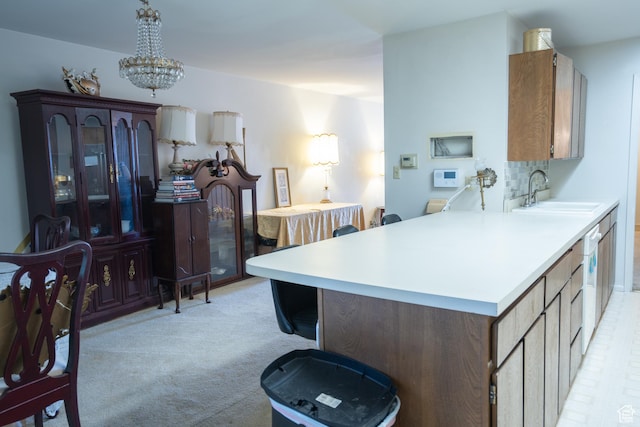 4971 S Beaver Brook Ln E Unit 40, Murray, UT 84117 - kitchen with light carpet, a notable chandelier, light countertops, and a sink