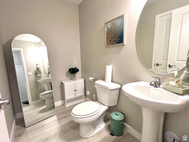 bathroom featuring baseboards, toilet, and wood finished floors