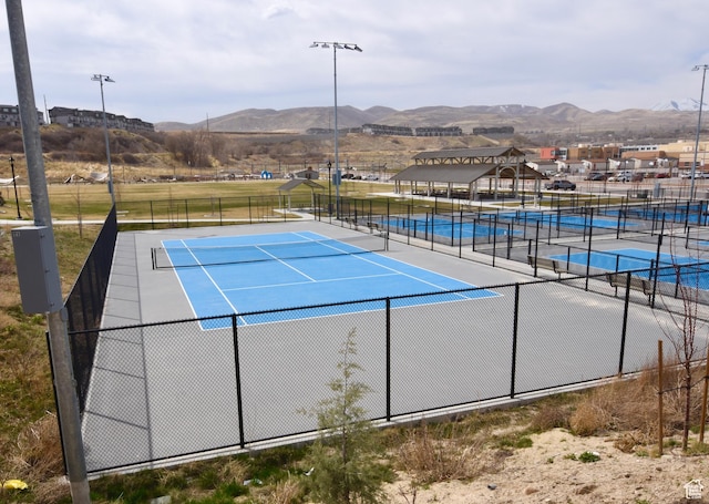 view of sport court featuring fence and a mountain view