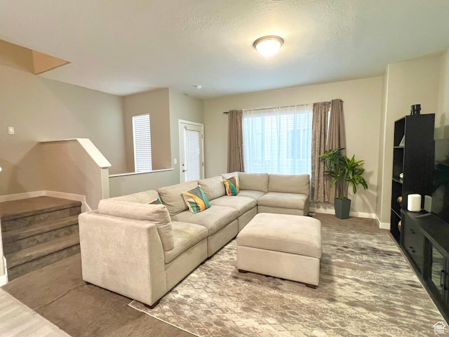 living area featuring stairs and baseboards
