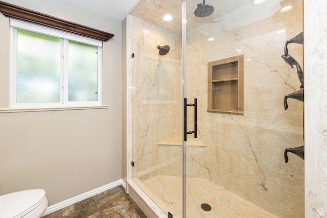 full bathroom with toilet, a marble finish shower, and baseboards