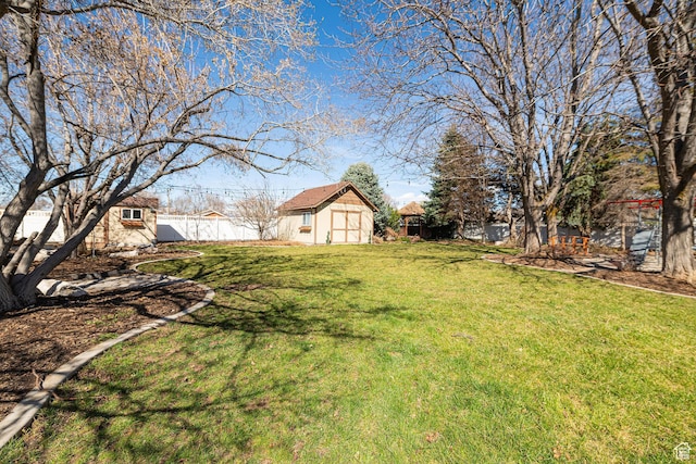 view of yard featuring a fenced backyard, a shed, and an outdoor structure
