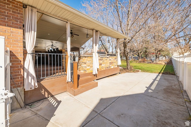 view of patio with fence and a ceiling fan