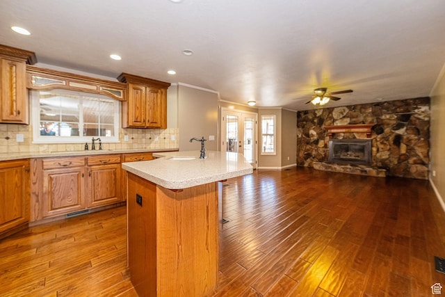 kitchen featuring open floor plan, dark wood finished floors, decorative backsplash, and ceiling fan