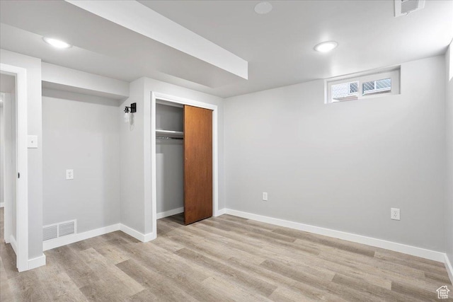 unfurnished bedroom with light wood-style flooring, a closet, and baseboards
