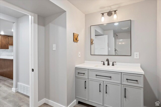 bathroom with baseboards, visible vents, wood finished floors, and vanity