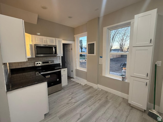 3677 Adams Ave, South Ogden, UT 84403 - kitchen with tasteful backsplash, light wood-type flooring, dark countertops, white cabinets, and appliances with stainless steel finishes