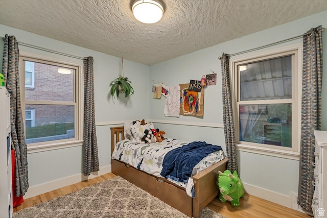 1311 E 29th St S, Ogden, UT 84403 - bedroom featuring baseboards, a textured ceiling, and wood finished floors