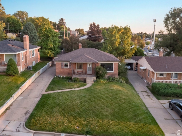 1311 E 29th St S, Ogden, UT 84403 - view of front of property featuring brick siding, central AC unit, a yard, and a chimney