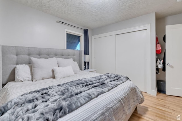 1311 E 29th St S, Ogden, UT 84403 - bedroom with a closet, a textured ceiling, and light wood-style flooring