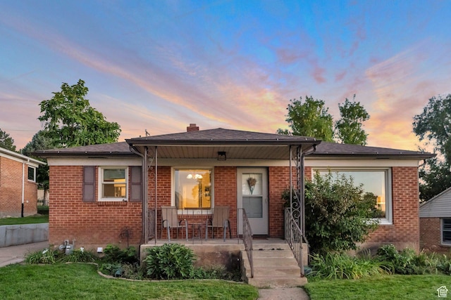 bungalow-style house featuring a porch and brick siding
