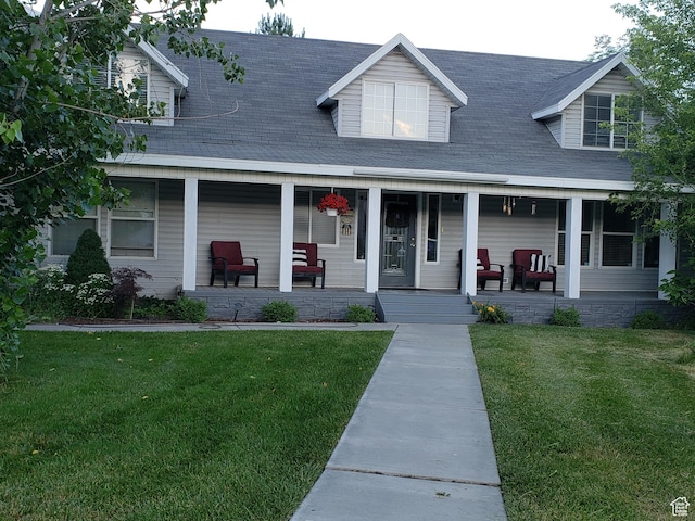 view of front of home featuring a shingled roof, a porch, and a front yard
